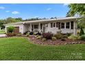 Charming brick home featuring a meticulously landscaped front yard and a welcoming front porch at 9135 Stokes Ferry Rd, Salisbury, NC 28146