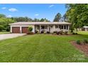 Beautiful home with a lush green lawn, a charming brick facade, and inviting curb appeal at 9135 Stokes Ferry Rd, Salisbury, NC 28146