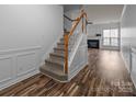 Entryway with staircase and wood floors leading to a living area with fireplace at 10207 Garmoyle St, Charlotte, NC 28277