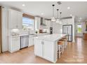 Modern kitchen with white cabinets, stainless steel appliances, and a large center island with seating at 1022 Paddlers Way # 136, Belmont, NC 28012