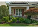 Cozy front porch with rocking chairs, lush landscaping, and charming curb appeal at 10405 Scotland Ave, Indian Land, SC 29707