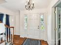 Bright foyer with decorative sidelights, hardwood floors, and a classic chandelier at 1049 Regency Dr, Charlotte, NC 28211