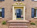 Welcoming entryway featuring a blue front door, brick steps, and decorative pillars at 1049 Regency Dr, Charlotte, NC 28211