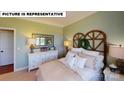 Bright bedroom featuring a decorative headboard, dresser, mirror, and comfortable bed with soft pillows at 124 S Shayna Rd, Troutman, NC 28166