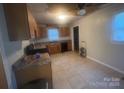 Functional kitchen features tile flooring, wooden cabinetry, and a window for natural light at 1313 Lower Dallas Hwy Hwy, Dallas, NC 28034