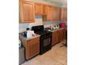 Kitchen features wooden cabinets, tile flooring, and black appliances at 1313 Lower Dallas Hwy Hwy, Dallas, NC 28034