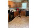 Kitchen featuring wooden cabinets, tile flooring, and black appliances at 1313 Lower Dallas Hwy Hwy, Dallas, NC 28034