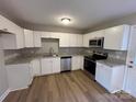 Modern kitchen with white cabinets, granite countertops, and stainless steel appliances at 1820 Wendover Dr, Lancaster, SC 29720