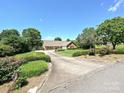 Well-manicured lawn with a long driveway leading to a beautiful brick home surrounded by trees at 202 Cameron Dr, Kings Mountain, NC 28086