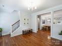 Bright foyer featuring gleaming hardwood floors, staircase, a bench, and a view into the dining room at 2222 Wilmore Dr, Charlotte, NC 28203
