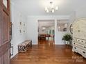 Inviting foyer with hardwood floors, elegant lighting, and bench seating with a view into the dining room at 2222 Wilmore Dr, Charlotte, NC 28203