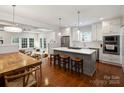 Open-concept kitchen with a large island, bar seating, and stainless steel appliances flowing into the living room at 2222 Wilmore Dr, Charlotte, NC 28203
