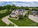 Stunning aerial view of a well-manicured property with lush greenery, solar panels, and a spacious driveway at 324 Squash Harvest Ct, Matthews, NC 28104
