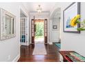 Inviting foyer with hardwood floors, decorative mirror, and a view of the beautifully landscaped front yard at 324 Squash Harvest Ct, Matthews, NC 28104