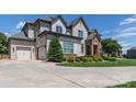 Beautiful exterior of home with well-maintained landscaping, large driveway and stone-accented entrance at 324 Squash Harvest Ct, Matthews, NC 28104