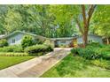 Exterior of charming home with mature trees, lush landscaping, and long driveway at 331 Glen Oaks Rd, Charlotte, NC 28270