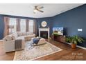 Cozy living room with dark blue walls, a fireplace, and plush sectional sofa at 3615 Slider Ter, Indian Land, SC 29720
