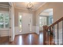 Elegant foyer with hardwood floors, wainscoting, arched doorways, and stylish light fixture at 3666 Jacinta Ct, Tega Cay, SC 29708