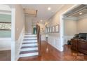 Spacious hallway with hardwood floors, staircase, wainscoting, and arched doorways at 3666 Jacinta Ct, Tega Cay, SC 29708