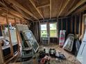 Unfinished interior showcasing exposed beams, window frames, and various construction materials at 5040 Fairview Church Rd, Lincolnton, NC 28092