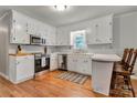 Cozy kitchen with white cabinets, stainless steel appliances, and wood flooring at 511 Apple Ln, Bessemer City, NC 28016