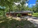 Charming brick home with attached carport nestled among mature trees at 511 Evelyn Ave, Kannapolis, NC 28083