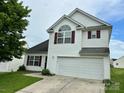 Charming two-story home featuring white siding, red shutters, and an attached two-car garage at 710 Woodington Ln, Charlotte, NC 28214