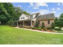 Charming two-story brick home with a large front porch, lush lawn, and mature landscaping at 803 Freeman Rd, Concord, NC 28025