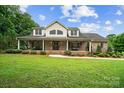 Charming two-story brick home with a large front porch, lush lawn, and beautiful landscaping at 803 Freeman Rd, Concord, NC 28025
