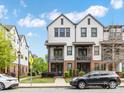 Two-story townhome with white siding, brick accents, covered balconies, and well-maintained landscaping at 933 E 36Th St, Charlotte, NC 28205