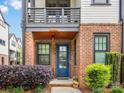Charming brick front porch with a blue door, complemented by potted flowers and lush greenery at 933 E 36Th St, Charlotte, NC 28205