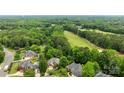A stunning aerial view of the neighborhood with its mature trees and lush greenery, with golf course in the distance at 10317 Clubhouse View Ln, Mint Hill, NC 28227