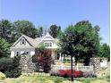 Picturesque home exterior with stone accents, a white picket fence, and lush landscaping at 104 Bunker Way # 1001, Mooresville, NC 28117