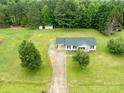 Aerial view of a home on a lot with a long driveway and surrounded by mature trees and lush greenery at 1274 Carpenter Springs Dr, Dallas, NC 28034
