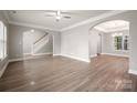 Open-concept living room with hardwood floors, archways, and staircase at 14034 Cedar Pond Cir, Huntersville, NC 28078