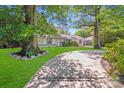 Inviting home featuring a digitally enhanced green lawn, mature trees, and a curved driveway at 2000 Tyvola Rd, Charlotte, NC 28210