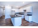 Modern kitchen features a central island, white cabinetry, and black countertops at 2541 Ruby Dixon Crossing Dr # 18, Gastonia, NC 28056