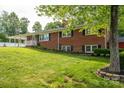 Brick home featuring manicured landscaping, black shutters, and a covered side porch on a sunny day at 2865 Water Plant Rd, Maiden, NC 28650