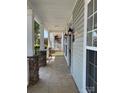 Spacious front porch featuring stone columns, neutral siding, and decorative outdoor lighting at 4135 Twenty Grand Dr, Indian Trail, NC 28079