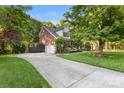 Long driveway leads to a charming brick home with lush greenery and a basketball hoop at 4389 Enchantment Cove Ln, Charlotte, NC 28216
