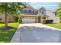 Inviting two-story home with a spacious driveway, attached garage, and beautifully landscaped front yard at 4935 Norman Park Pl, Clover, SC 29710