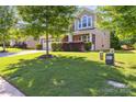 Beautifully landscaped front yard with lush green grass, mature trees, and manicured shrubbery at 4935 Norman Park Pl, Clover, SC 29710