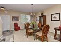 Dining area featuring a glass table with seating for six under a decorative chandelier at 5011 Blue Stream Ln, Indian Trail, NC 28079