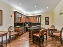 Charming kitchenette with hardwood floors, custom cabinetry, granite countertops, and seating area at 5425 Closeburn Rd, Charlotte, NC 28210