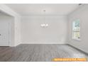 Open dining room area with a stylish chandelier, large window, and luxury vinyl flooring at 6005 Jasmine Branch Rd, Charlotte, NC 28216
