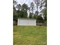 Two car detached garage sitting in the backyard with a fresh coat of paint and rolling metal doors at 730 Cove Rd, Gastonia, NC 28052
