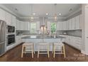 Open kitchen with sleek white cabinets, stainless steel appliances, and an island with barstool seating at 859 Academy St, Charlotte, NC 28205