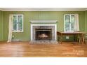 The living room features a brick fireplace with white mantle, two windows and hardwood floors. Perfect for relaxing at 9139 Robert Frost Ln, Charlotte, NC 28213
