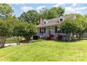 Classic home featuring landscaped front yard and brick chimney surrounded by mature trees offering shade and curb appeal at 952 8Th Ne St, Hickory, NC 28601