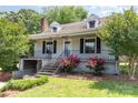 Charming home with landscaped front yard, featuring vibrant roses, inviting entrance, and classic architectural details at 952 8Th Ne St, Hickory, NC 28601